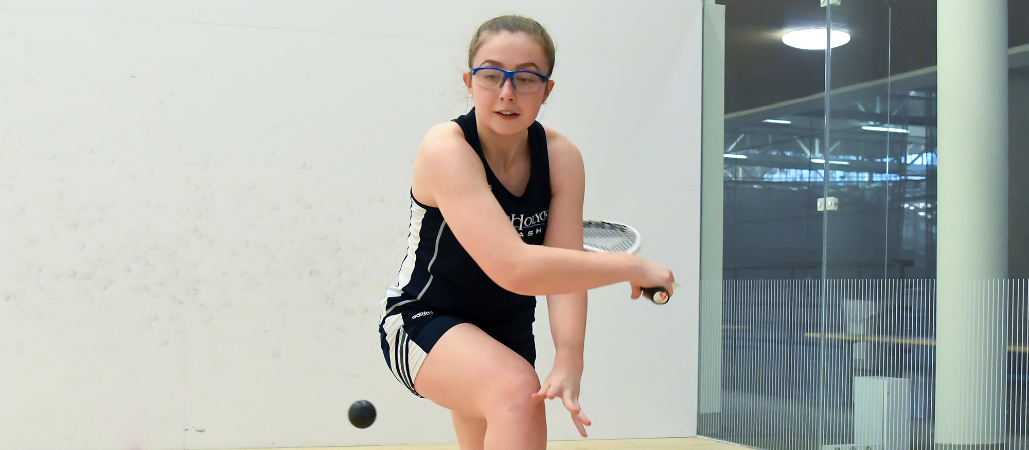 Action photo of Lyons squash player, Maeve Watts-Roy.