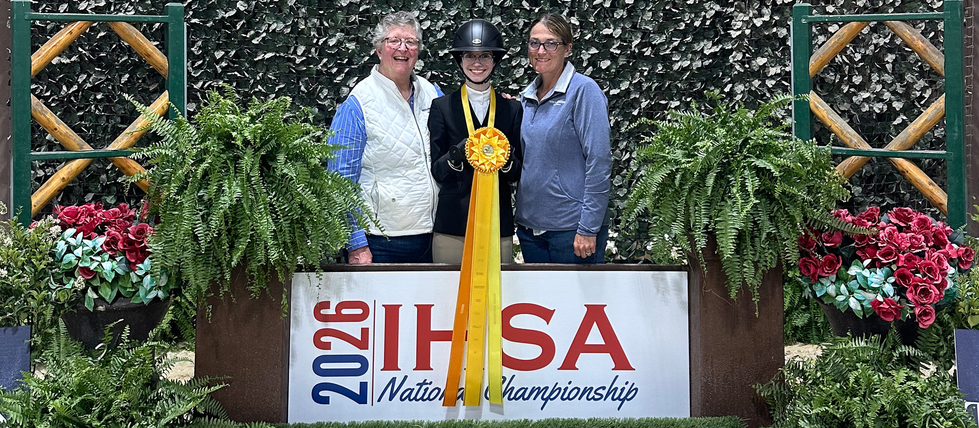 Flanked by head coach C.J. Law (left) and assistant coach Morgan Lynch (right), Lainey Nibbio (center) placed third in the individual novice division at IHSA Nationals on May 1, 2026.