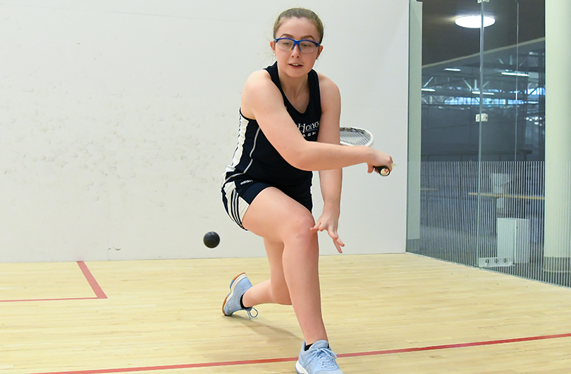 Action photo of Lyons squash player, Maeve Watts-Roy