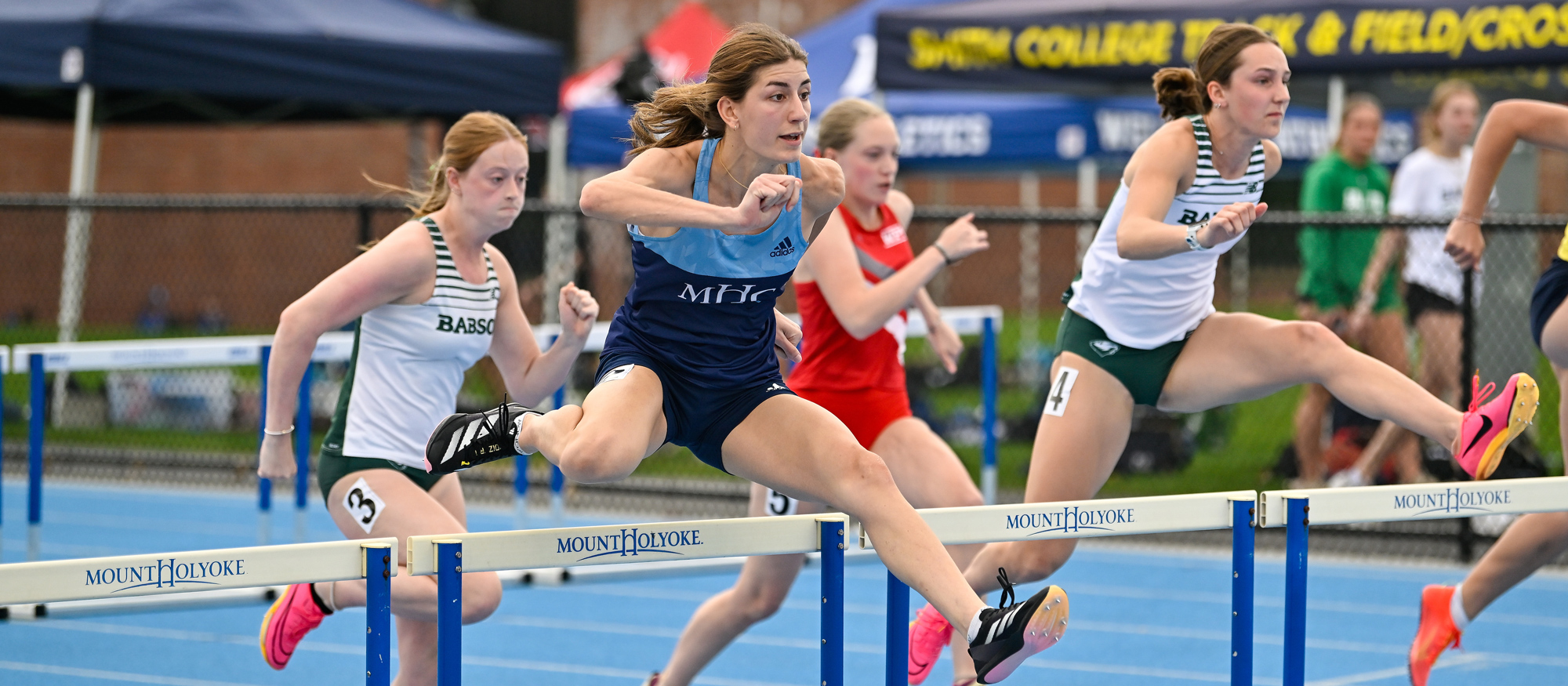 Ioanna Tsoni placed second in the 100 hurdles, winning All-NEWMAC honors to go with her long jump title, at the NEWMAC Championships at Mount Holyoke on April 26, 2025. (Bob Blanchard/RJB Sports)