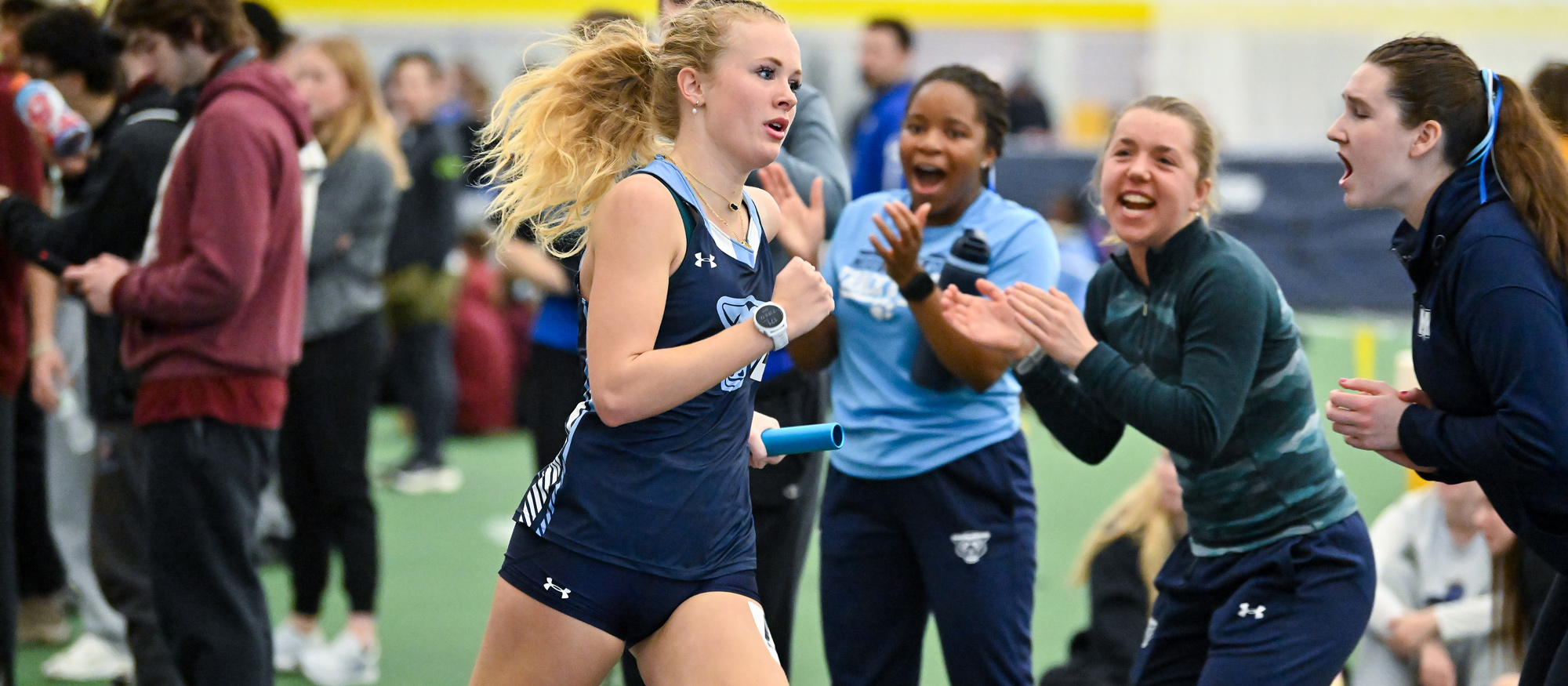 Katherine Herring runs a leg of the 4x400 relay with teammates cheering her on at Smith College on Jan. 31, 2026. (Bob Blanchard/RJB Sports)