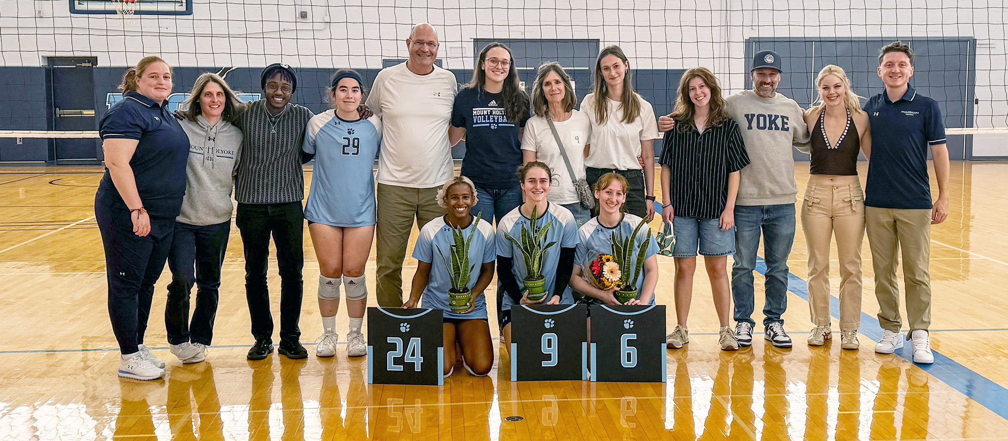 Supporters of Mount Holyoke volleyball's senior class (left to right, Dinanyelin Martinez, Lucie Berclaz, and Barah Burns -- gather before their Senior Day match on Nov. 2, 2024. (KJ Reese)